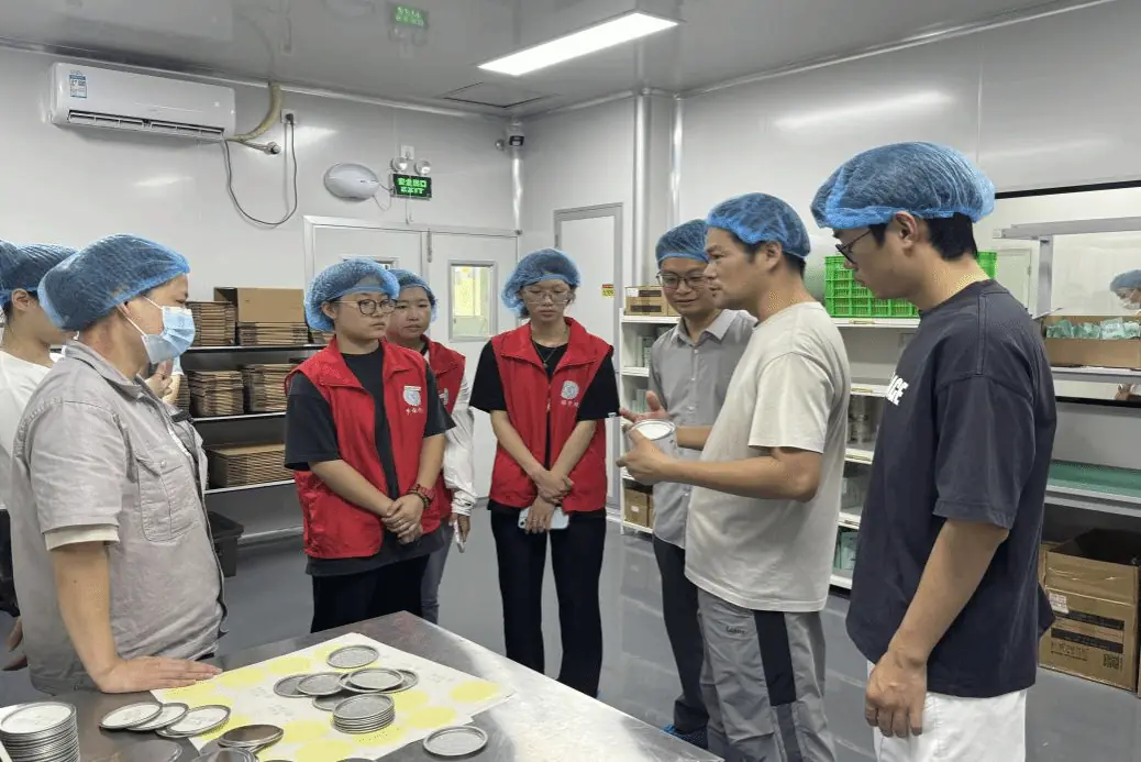 陈发来在发来茶业包装车间向来访师生介绍茶罐与包装